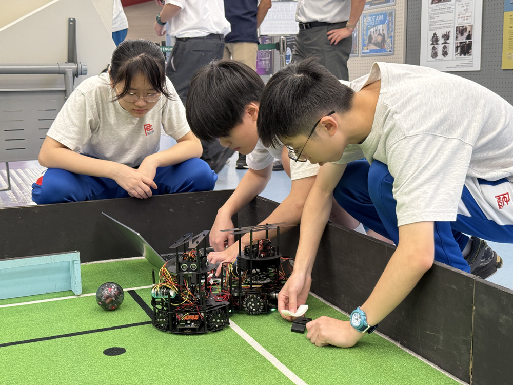 Students test their robot and coding before the challenge of robot soccer.