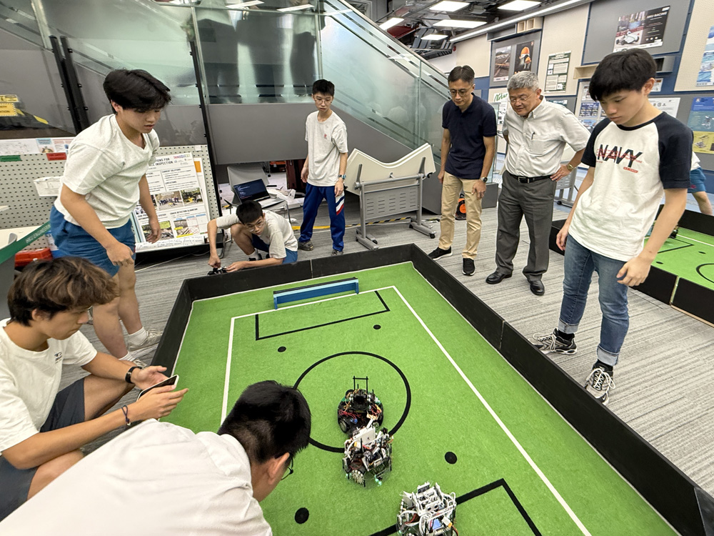 During the robot soccer competition, Prof. Ngai WONG and Dr. Victor Chung Sing LEE of the HKU-EEE commended the students' innovative mechanical designs and programming strategies.